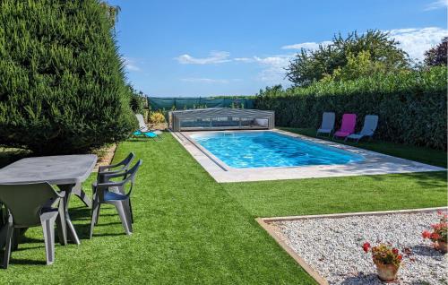 un patio trasero con piscina, mesa y sillas en Stunning Home In Ceaux-En-Loudun, en Ceaux-en-Loudun