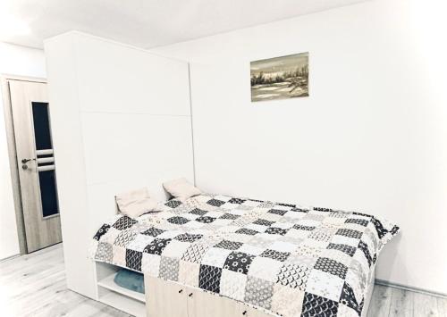 Un dormitorio blanco con una colcha blanca y negra sobre una cama. en M&M Apartment I near Panevezys, en Velžys