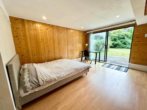 a bedroom with a bed and a wooden wall at Beautiful Place with Kitchen, Washing Machine and Internet Near YVR Airport, Transit and Shopping Mall in Richmond
