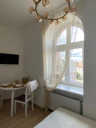 una camera da letto con un tavolo e una finestra con un lampadario di Golden Rush a Riga