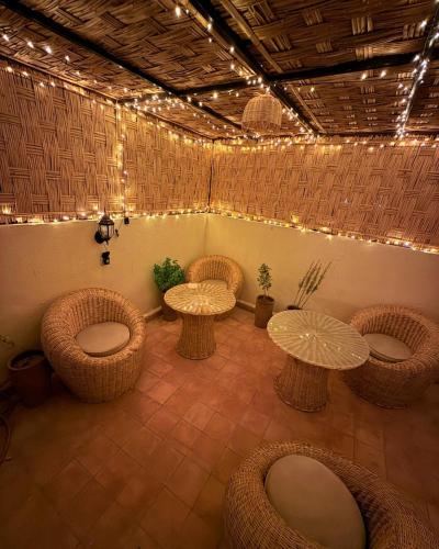 a room with wicker tables and chairs and lights at Dar Skouri 51 in Marrakesh