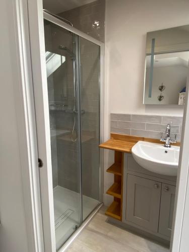 a bathroom with a shower and a sink at Boutique Burnham Market Cottage in Burnham Market