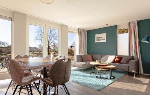 Una sala de estar con una mesa y sillas y un sofá. en Nice Home In Makkum With Lake View, en Holle Poarte