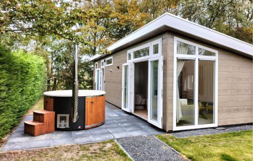 a small house with a hot tub in the yard at 2 Bedroom Cozy Home In Heinkenszand in Graszode