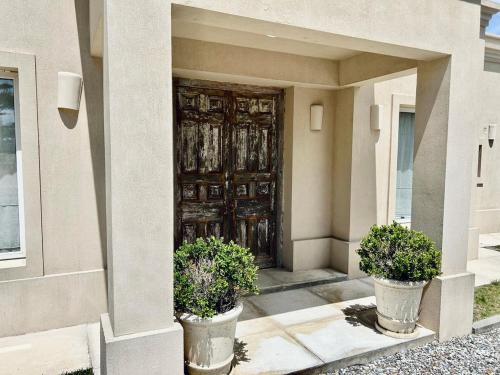サン・グレゴリオ・デ・ポランコにあるSpectacular house in a private neighborhoodの鉢植え二本家の玄関