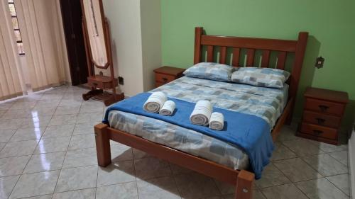 a bedroom with a bed with three towels on it at Casa Jardim da Serra in Juiz de Fora