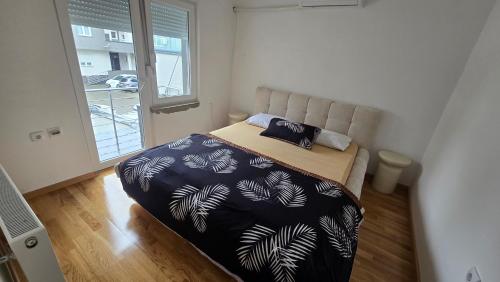 a bedroom with a bed with a black and white comforter at Bazen za uzivanje in Petrovaradin