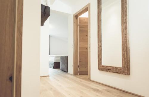 a mirror on the wall in a hallway with a room at Designhotel Sonnhof by Vitus Winkler in Sankt Veit im Pongau