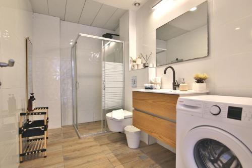 bagno con lavatrice e doccia di Luxe on the BEACH By LIME a Haifa