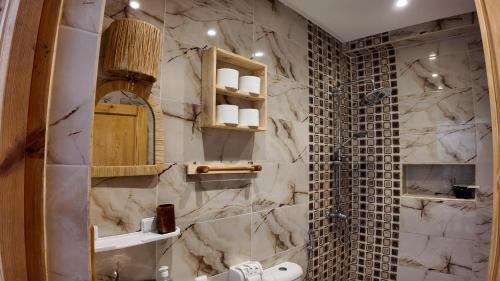 a bathroom with a shower and a marble wall at La casa de Oasis in Essaouira