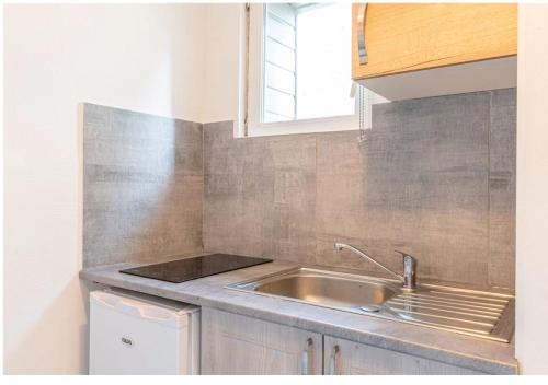a small kitchen with a sink and a window at Le Refuge marin Douce escapade à 100m de la mer in Luc-sur-Mer