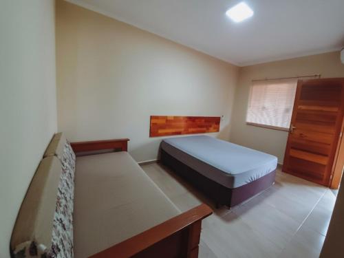 Un dormitorio pequeño con una cama y una cómoda. en Pousada Ilha Sul, en Cananéia