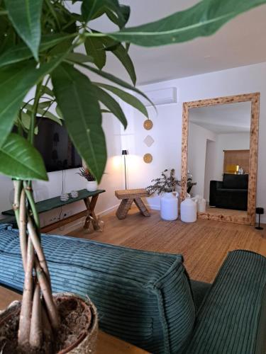 a living room with a potted plant and a mirror at Casa do Logradouro in Alcochete