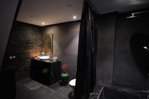 a black bathroom with a toilet and a shower at Entre Medina et Mer Duplex in Rabat
