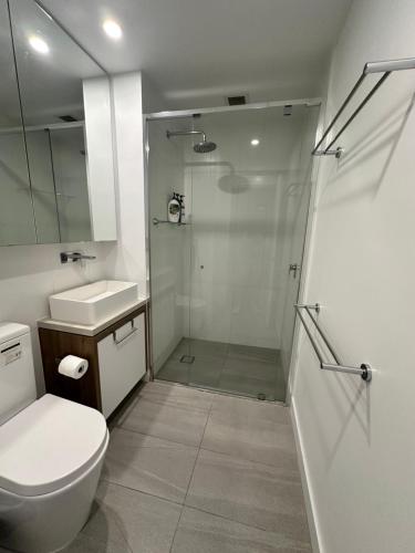 a bathroom with a shower and a toilet and a sink at Fortitude Valley Stylish Comfortable Apartment in Brisbane