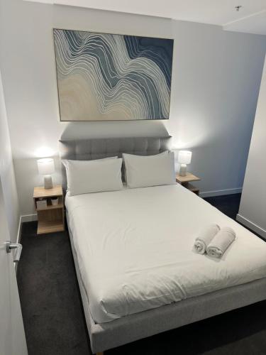 a bedroom with a bed with two slippers on it at Fortitude Valley Stylish Comfortable Apartment in Brisbane