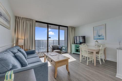 a living room with a couch and a table at 0609 Oceanfront Escape by Atlantic Towers in Carolina Beach
