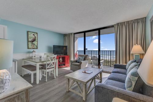 a living room with a couch and a table at 0306 Oceanfront Oasis by Atlantic Towers in Carolina Beach