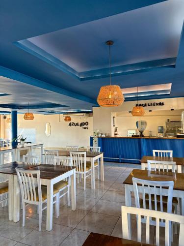 a restaurant with white tables and chairs and a blue ceiling at Azul Hotel & Spa in Oberá