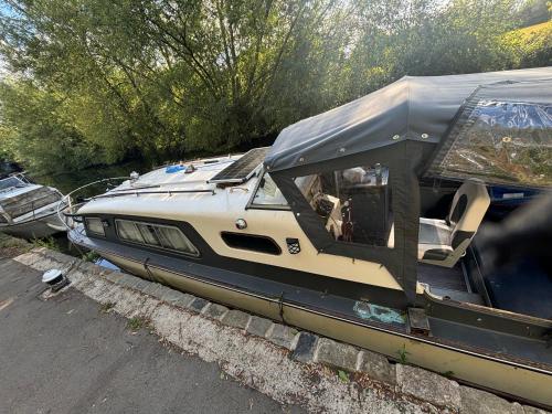 a boat with a tent on the side of a road at 4 berth Boat house in birstall, Leicester in Birstall