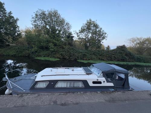 a boat is docked on the water in a river at 4 berth Boat house in birstall, Leicester in Birstall