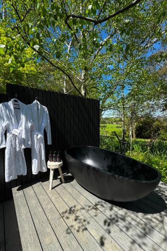 a large black bath tub sitting on a wooden table at The Pavilion Yarra Valley luxury country retreat in Coldstream
