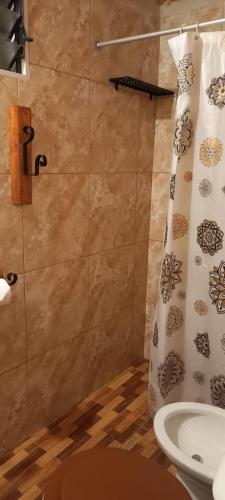 a bathroom with a shower curtain and a sink at Los Espinillos Cabaña Exclusiva in Huerta Grande