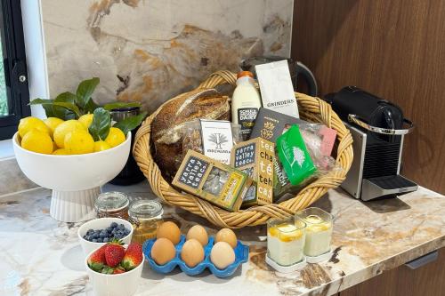 Una cesta de pan, huevos y fruta en un mostrador. en The Pavilion Yarra Valley luxury country retreat, en Coldstream