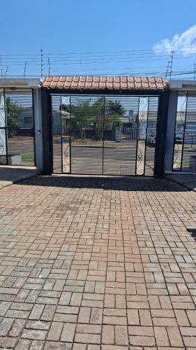 a building with a gate and a brick patio at Casa 5 estrelas in Cascavel