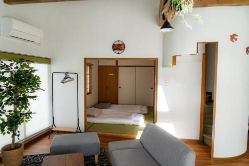 een kamer met een bed, een bank en een spiegel bij ウィステリア in Teshikaga