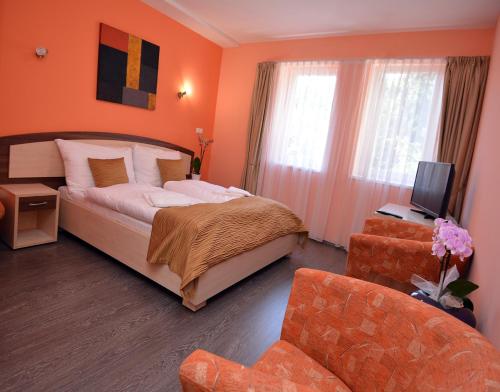 a bedroom with a bed and a tv and a couch at Bartal Rodinné Vinárstvo in Šamorín