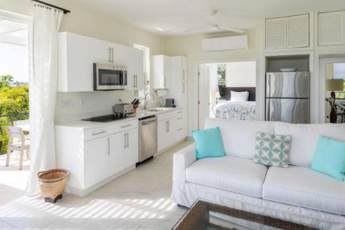 a living room with a white couch and a kitchen at Wyakha Duplex 1 & 2 in Long Bay Hills