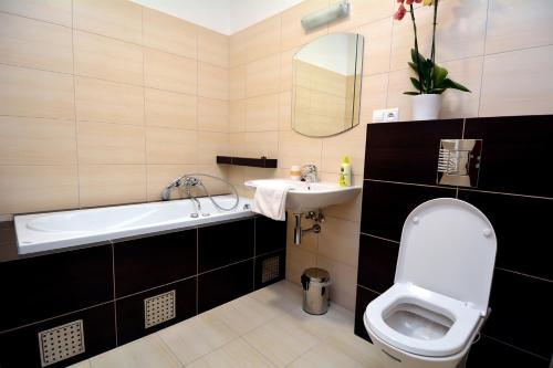 a bathroom with a toilet and a sink and a tub at Bartal Rodinné Vinárstvo in Šamorín
