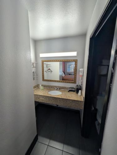 a bathroom with a sink and a mirror at Crossroads Inn - Downtown Sacramento in Sacramento