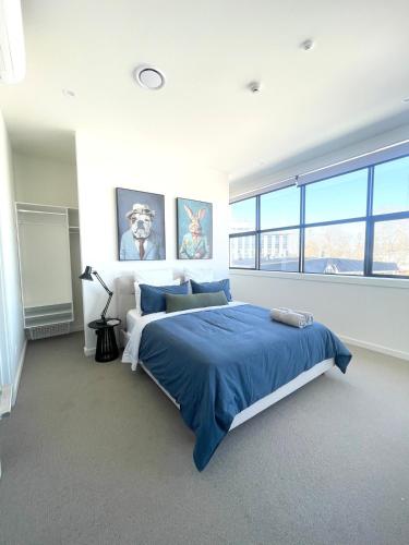 a bedroom with a large bed with blue sheets at Love Our Loft in Napier
