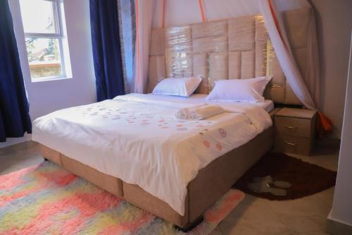 a bedroom with a large bed with a canopy at Pineapple Apartments in Jinja