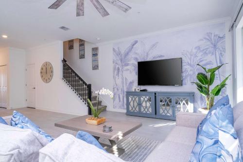a living room with a tv on a wall at NEW to Market 5 Bed - Storey Lake Retreat in Kissimmee