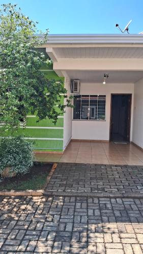 a white house with a door and a patio at Casa 5 estrelas in Cascavel