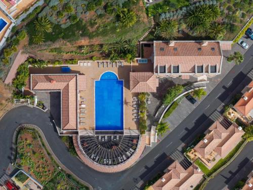 an overhead view of a house with a swimming pool at Balancal Apartments and Villas Palheiro Village in Funchal