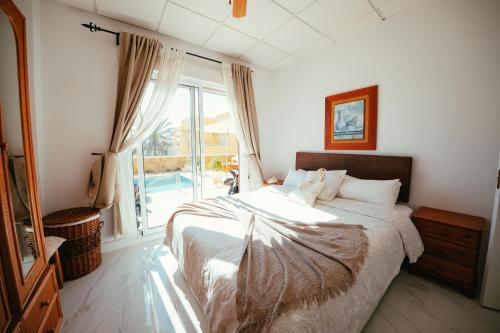 a bedroom with a bed and a large window at Villa Dahi Almerimar 10 Guest, Prive Pool, Prive Bar, BBQ, Sea Views in Almerimar