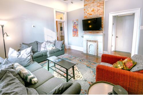 a living room with two couches and a fireplace at Kerlerec Victorian Cottage - Steps to French Qtr. in New Orleans