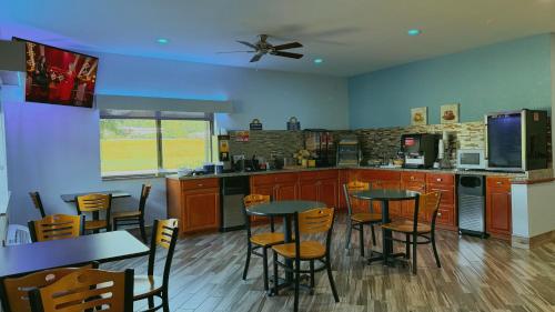 a kitchen with tables and chairs and a kitchen with blue walls at Days Inn by Wyndham Mankato in Mankato