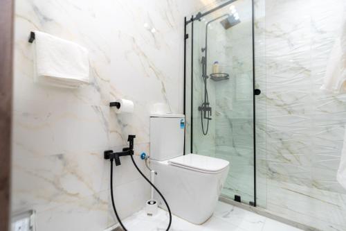 a bathroom with a toilet and a glass shower at Welcomly 10 - Luxury apartment in Tangier in Tangier