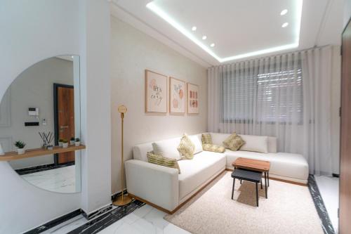 a living room with a white couch and a mirror at Welcomly 10 - Luxury apartment in Tangier in Tangier