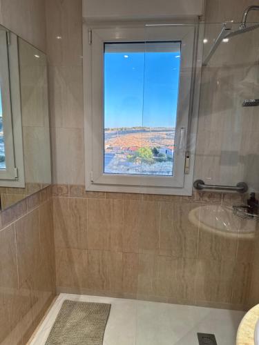 a bathroom with a window and a sink and a shower at El Rincón del Marqués in Las Navas del Marqués