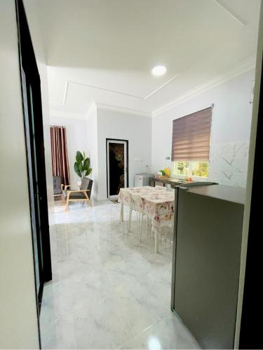 a living room with a table and a kitchen at Bunohan Villa Homestay in Tumpat