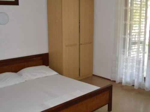 una camera da letto con un letto e un armadio in legno di Apartments Miki Rogoznica - Classic Two Bedroom Apartment with Terrace a Podglavica