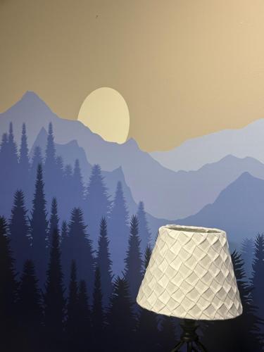 a lamp in front of a forest with mountains at Mountain View 3BDR with Hot Tub, Game Loft and Deck in Sugar Mountain
