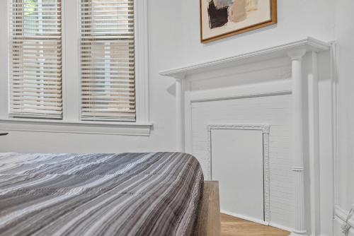 a white bedroom with a bed and a fireplace at Pittsburgh Shadyside 1C Spacious and Cozy Private Bedroom with Shared Bathroom in Pittsburgh