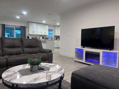 a living room with a couch and a tv at Place to stay in Hallandale Beach